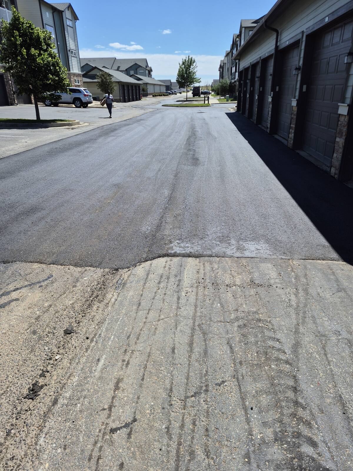 New asphalt patch in the lane in front of a row of garage bays