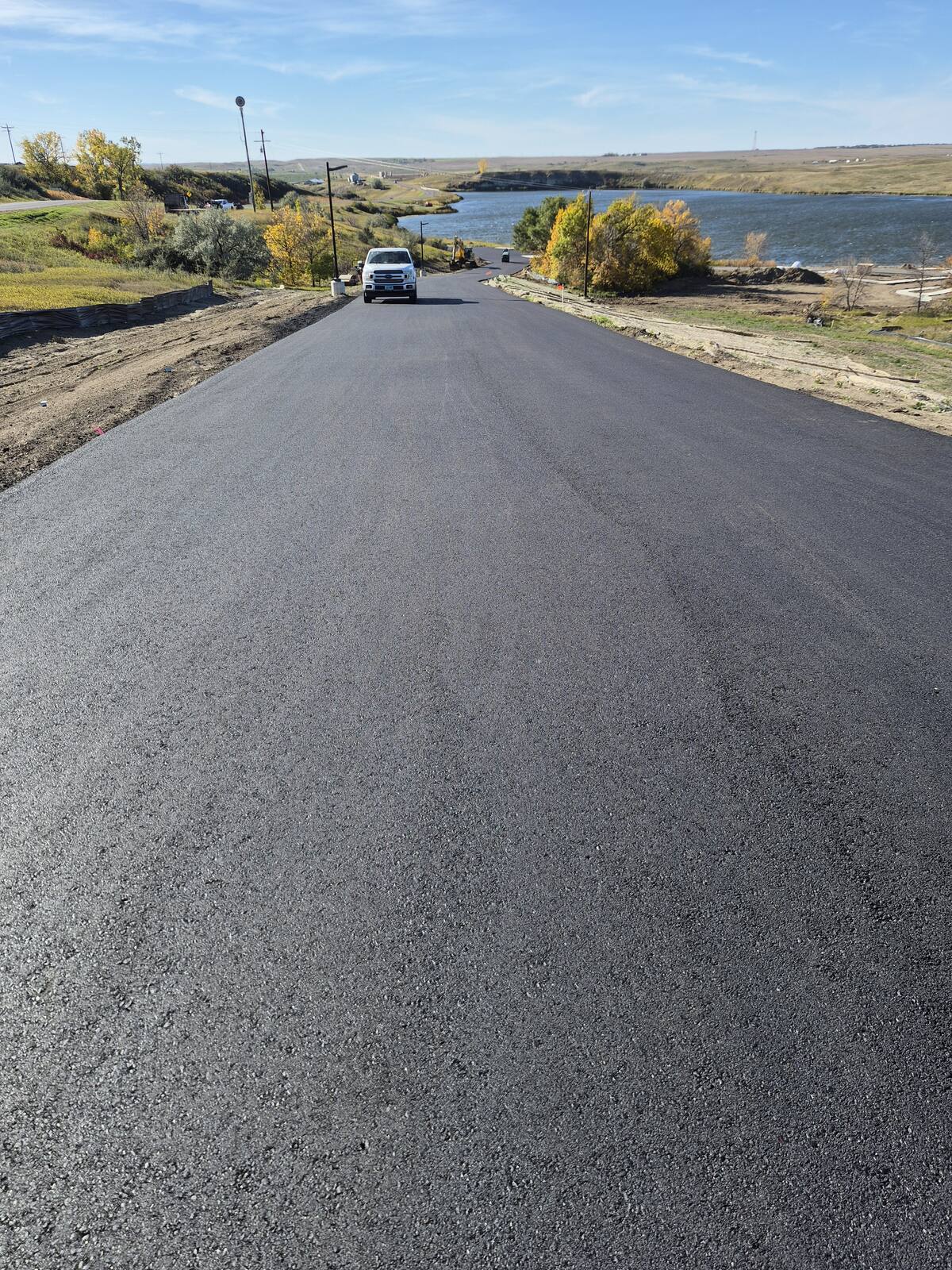 New asphalt park road running down toward the lake at Blacktail Dam