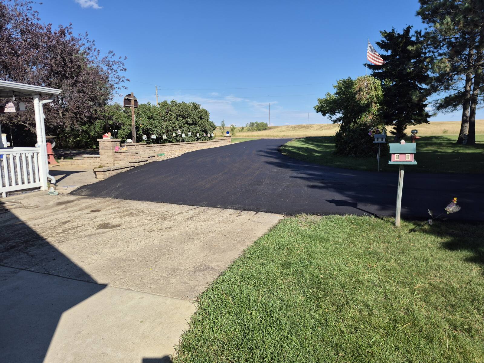 New asphalt driveway approach beside the front porch and mailbox