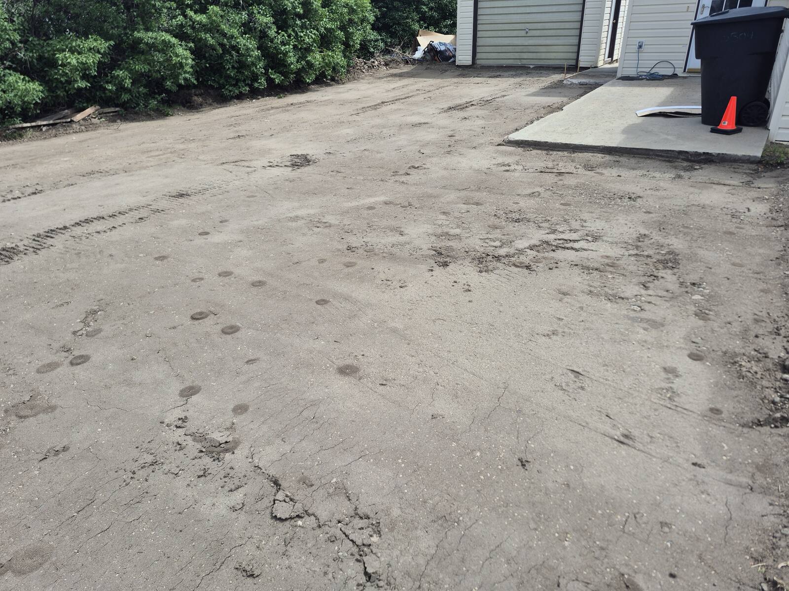 Bare graded dirt after the concrete and sod were removed