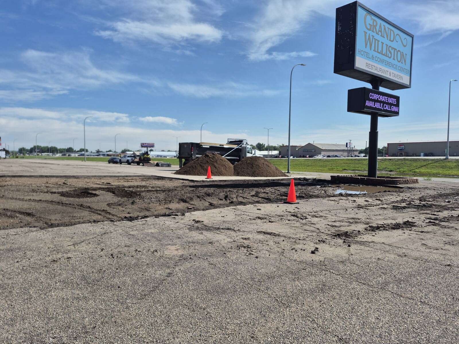Skid steer tearing out failed asphalt at the Grand Williston Hotel