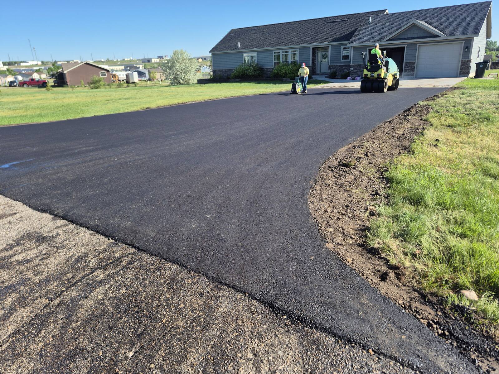 Roller compacting the curved section of the new driveway