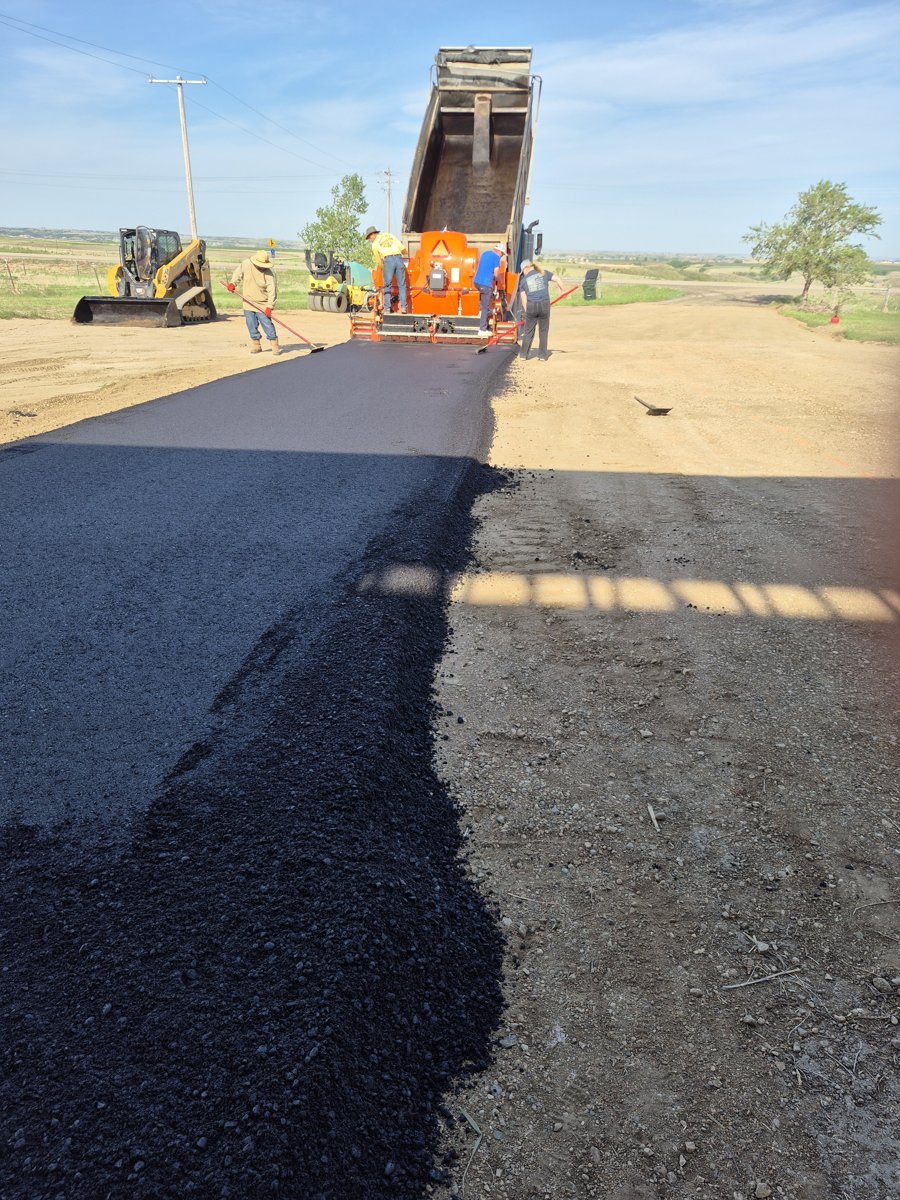 Asphalt paver laying a rural oilfield access road in the Bakken