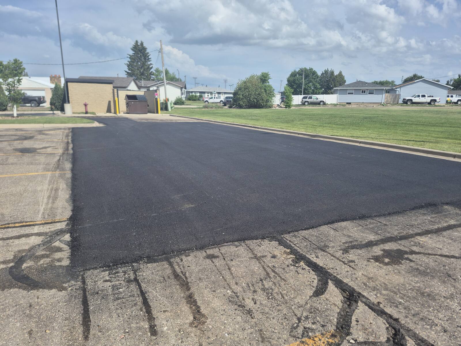 New asphalt patch at the edge of the lot after milling and overlay